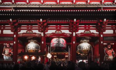 Night view of Senso-ji Temple in Tokyo, showcasing large lanterns and traditional architecture.
