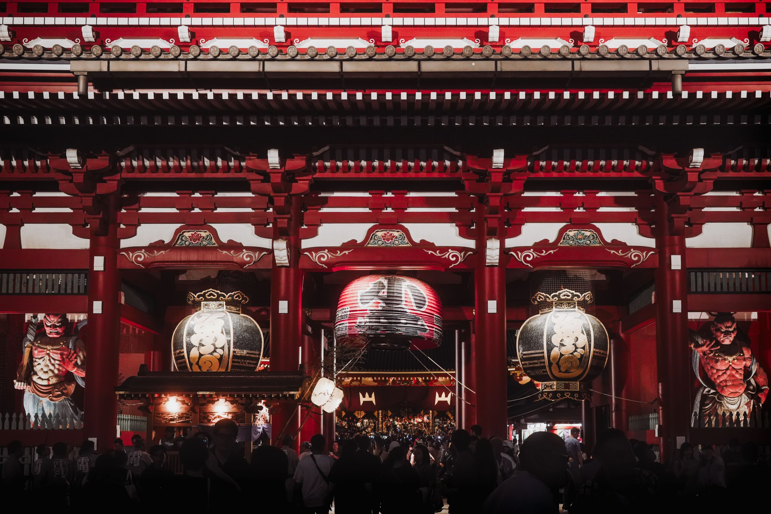 Night view of Senso-ji Temple in Tokyo, showcasing large lanterns and traditional architecture.